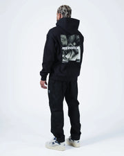 Black BJJ hoodie full body back lifestyle shot with adult male model showing Pursue The Gentle Art print