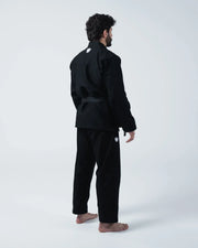 Kingz Kore V2 BJJ Gi Black - 3/4 Angled Back View Male Athlete Standing Wearing Black Kimono Crown Logo Hip Patch