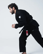 Kingz Kore V2 BJJ Gi Black - Full Body Side Profile View Male Athlete Dynamic Walking Stance Crown Logo Chest Patch Black Belt