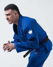 Kingz Kore V2 BJJ Gi Blue - Side Profile View Athlete Leaning Forward Dynamic Fighting Stance Crown Logo Chest Patch Black Belt