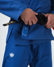 Kingz Balistico 4.0 BJJ Gi Blue waist closeup showing hands tying black belt and Balistico jacket label