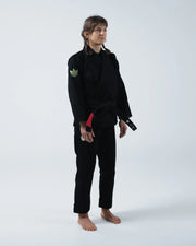 Kingz The ONE V2 Women's Jiu Jitsu Gi Black - Full Body Front View Female Athlete Black Gi Green Crown Badge Left Arm Black Belt Traditional Fit BJJ Gi Training [color:Black]