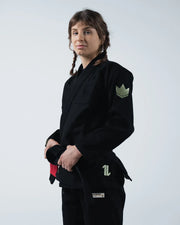 Kingz The ONE V2 Women's Jiu Jitsu Gi Black - Upper Body Front View Female Athlete Black Gi Green Crown Patch Left Arm Embroidered Logo Left Waist Durable Fabric BJJ Training Gi [color:Black]