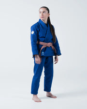 Kingz The ONE V2 Women's Jiu Jitsu Gi Blue - Full Body Front View Female Athlete Blue Gi White Crown Badge Shoulder Brown Belt KINGZ Logo Hem Durable Fabric Design BJJ Gi Training [color:Blue]