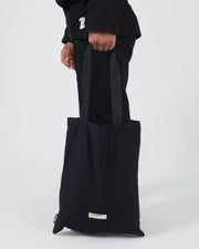 Kingz The ONE V2 BJJ Gi Black athlete holding included black Kingz gi bag with number one logo above