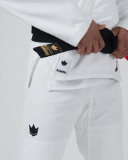 Kingz The ONE V2 BJJ Gi White waist closeup showing hand on gold label belt and crown Kingz logo