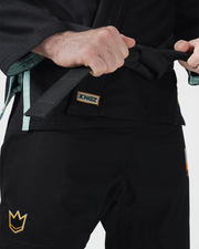 Kingz Nano 3.0 Terra LE BJJ Gi Black waist closeup showing hands tying belt and gold Kingz label