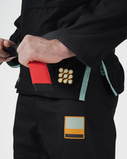 Kingz Nano 3.0 Terra LE BJJ Gi Black hip closeup showing gold Nano dot logo and earth tone Terra patch