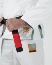 Kingz Nano 3.0 Terra LE BJJ Gi White hip closeup showing hand on red bar belt and earth tone Terra patch