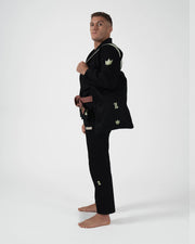 Kingz The ONE V2 LE BJJ Gi Black Green side profile lifestyle view with gi bag and green crown logos