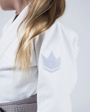 Close-up of a person wearing a white waffle-knit martial arts gi jacket with a gray belt, showing the shoulder and upper arm with a light gray embroidered crown logo.