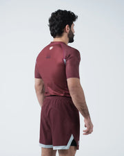 Kingz Trooper Rashguard Maroon - Full Body 3/4 Back View Left Side Male Athlete Short Sleeve Crown Logo Left Shoulder Maroon Shorts Gray White Trim
