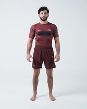 Kingz Trooper Rashguard Maroon - Full Body Straight Front View Male Athlete Barefoot Short Sleeve KINGZ Logo Black Chest Band Flag Patches Maroon Shorts
