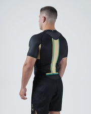 Kingz Player Special Limited Edition Rashguard Black Gold Green - Full Body Straight Back View Male Athlete Short Sleeve Lotus JPS Colors Gold Green Center Back Stripe Crown Logo [color:Black]