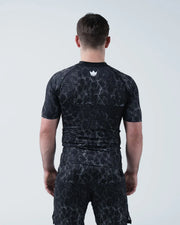 Kingz Acid Wash Rashguard Black - Full Body Straight Back View Male Athlete Short Sleeve Crown Logo Upper Back White Dot Acid Wash Pattern Matching Shorts Compression Fit