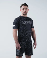 Kingz Acid Wash Rashguard Black - Full Body 3/4 Angled Front View Male Athlete Short Sleeve Large KINGZ White Outline Text Crown Logo Acid Wash Dot Pattern Matching Shorts