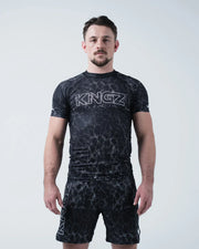 Kingz Acid Wash Rashguard Black - Full Body Front View Male Athlete Short Sleeve Black White Dot Acid Wash Pattern Large KINGZ Text Chest Matching Shorts Modern Design