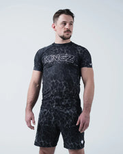 Kingz Acid Wash Rashguard Black - Full Body Front View Male Athlete Short Sleeve Large KINGZ Bold Text White Outline Black Dot Acid Wash Sublimated Pattern Matching Shorts