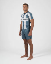 Kingz Vintage Futebol Rashguard Blue White Stripe - Full Body Right Side Profile View Barefoot Male Athlete Short Sleeve Retro Football Kit Vertical Stripes Gray Shorts