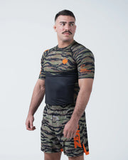 Kingz Always Hunting Rashguard Green Camo - Full Body 3/4 Angled Front View Male Athlete Short Sleeve Tiger Camo Orange Crown Logo KINGZ Originals Badge Camo Shorts