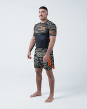 Kingz Always Hunting Rashguard Green Camo - Full Body Front View Barefoot Male Athlete Short Sleeve Tiger Camo Orange Crown Logo KINGZ Performance Badge Camo Shorts