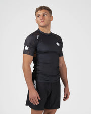 Kingz Ranked Performance V3 S/S Rashguard Brown - Upper Body 3/4 Angled Front View Male Athlete Short Sleeve Crown Logo Brown Orange Dot Pattern Shoulders White Chevron Sleeve Detail