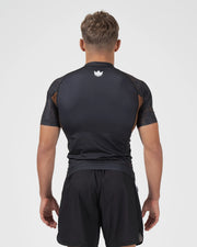 Kingz Ranked Performance V3 S/S Rashguard Brown - Full Body Straight Back View Male Athlete Short Sleeve Crown Logo Centered Upper Back Brown Orange Dot Pattern Sleeves