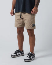 Kingz Casual Gi Shorts Khaki Tan Beige - 3/4 Front View Hand on Drawstring Male Athlete Khaki Ripstop Casual Shorts Black Drawstring Visible Woven Kingz Label Right Thigh Dark Navy T-Shirt Black White Dunk Sneakers Men's BJJ Lifestyle [color:Khaki]