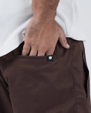 Kingz Casual Gi Shorts - Brown - Close-Up Detail View Hand in Pocket Earthy Brown Fabric Subtle Grid Pattern Black Crown Logo Tag Grappling Shorts BJJ Training [color:Earthy brown]