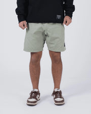 Kingz Casual Gi Shorts Sage Stone Green - Full Body Front View Male Athlete Sage Stone Green Ripstop Casual Shorts Above-Knee Cut Elastic Leg Hem Drawstring Waistband Black Woven Kingz Label Right Thigh Black Hoodie Brown Nike Dunk Sneakers Men's BJJ Lifestyle [color:Stone Green]