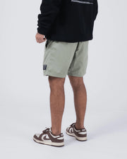 Kingz Casual Gi Shorts Sage Stone Green - Full Body Left Side Profile Male Athlete Sage Ripstop Casual Shorts Relaxed Fit Roomy Side Pocket Black Woven Kingz Label Right Thigh Black Hoodie Brown Nike Dunk Sneakers Men's BJJ Lifestyle [color:Stone Green]