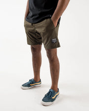 Kingz Casual Gi Shorts Military Green Dark Olive - Full Body Right Side Profile Hand in Pocket Male Athlete Dark Olive Ripstop Shorts KINGZ Label Right Thigh Black Drawstring Black T-Shirt Blue Suede Sneakers Men's BJJ Lifestyle [color:Military Green]