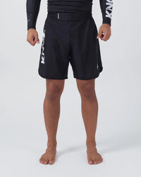 Kingz Kore V2 Shorts Black - Full Body Front View Male Athlete Black Lightweight Grappling Shorts Large KINGZ White Text Left Outer Thigh Crown Logo Right Thigh Elastic Waistband Competition Cut Mid-Thigh Length Black KINGZ Rashguard Bare Feet Men's No-Gi BJJ MMA Kore Collection
