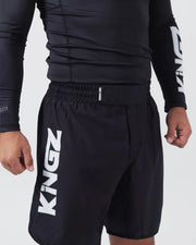 Kingz Kore V2 Shorts Black - Close Up Left Thigh Detail Large KINGZ White Vertical Text Left Outer Thigh KINGZ KIMONOS Small Text Elastic Waistband Black Lightweight Grappling Fabric Men's No-Gi BJJ MMA Kore Collection