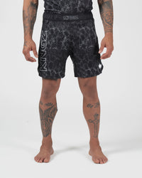 Kingz Acid Wash Shorts Black - Full Body Front View Tattooed Male Athlete Black White Dot Acid Wash Pattern KINGZ Bold Waistband Text KINGZ Large Left Leg Text Crown Badge Right Thigh Competition Cut Men's Grappling Shorts No-Gi BJJ