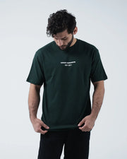 Kingz Solo Tee - Front Looking Down Pose - Kingz Kimonos Est 2011 Chest Text Clearly Visible - Dark Green BJJ
