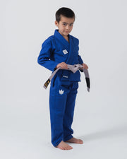 Kingz Kore V2 Youth BJJ Gi Blue - Full Body Front View Youth Athlete Gray Belt KINGZ Logo Tying Belt Pose Youth Kids