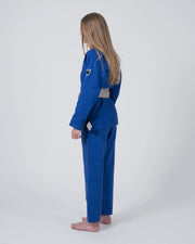 Kingz Nano 3.0 Youth BJJ Gi Blue - Full Body Side Profile View Girl Athlete Gray Belt Crown Logo Youth Kids Lightweight Gi