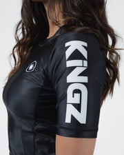 Kingz Kore V2 Short Sleeve Rashguard Black - Close Up Sleeve Detail KINGZ Bold White Oversized Text Sleeve Black Body JIU JITSU ROYALTY Crown Badge Left Chest Sublimated Graphics Women's BJJ Kore Collection Performance