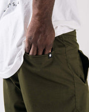 Kingz Casual Rip Stop Gi Pants Military Green - Close-Up Side View Hand in Pocket Crown Badge Black Tag Rip Stop Fabric Texture BJJ Gi Training Apparel [color:Military Green]