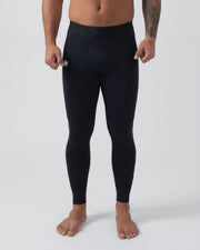 Kingz Kore Grappling Spats Black - Full Body Front View Shirtless Tattooed Male Athlete All-Black High-Waist Small White Crown Logo Left Thigh Bare Feet Full-Length Compression Fit Men's No-Gi BJJ Spats Kore Collection
